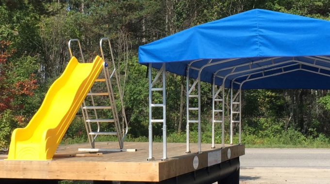 NyDock floating dock on land with a yellow slide and tent.