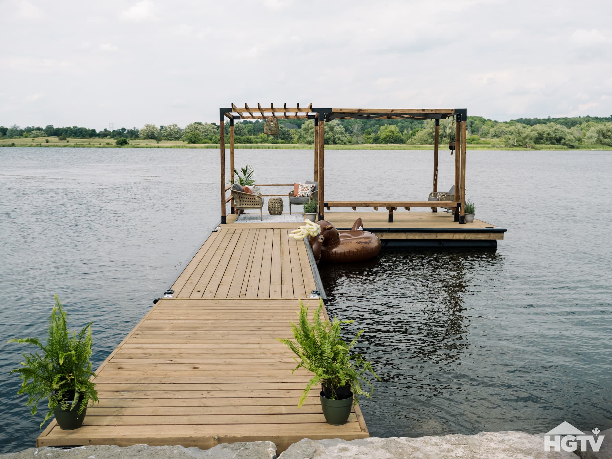 NyDock floating HDPE pontoon dock attached to rocky shoreline and decorated by HGTV